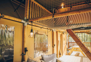 Innenaufnahme eines Safarizelts mit Holzkonstruktion, Netzdecke und Terrasse im Wilsumer Berge, Deutschland.