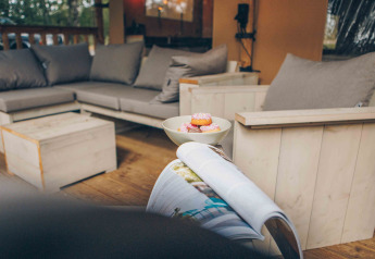 Gemütlicher Lounge-Bereich eines Safarizelts im Wilsumer Berge, Deutschland, mit Sofas und Snacks.