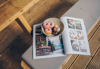 Eine Schale mit Donuts und Pralinen auf einer geöffneten Zeitschrift in einem Safarizelt bei Wilsumer Berge.