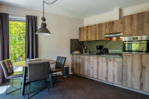 Cocina moderna y zona de comedor en Wellness Lodge en Vakantiepark De Wiltzangh, Países Bajos.