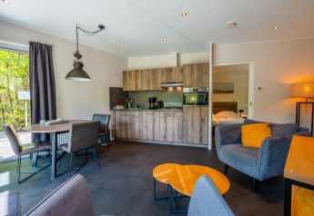 Salon moderne d'une Wellness Lodge avec cuisine ouverte et coin repas au Vakantiepark De Wiltzangh.