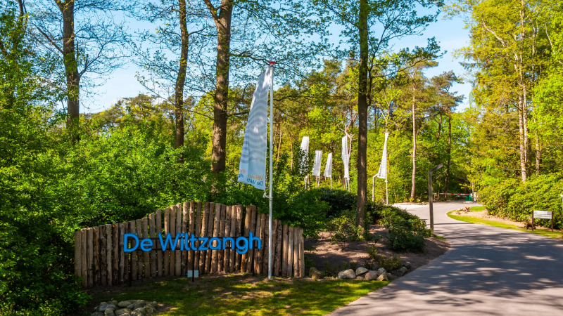 Eingang zur Wellness Lodge im Vakantiepark De Wiltzangh in den Niederlanden, umgeben von grüner Natur.