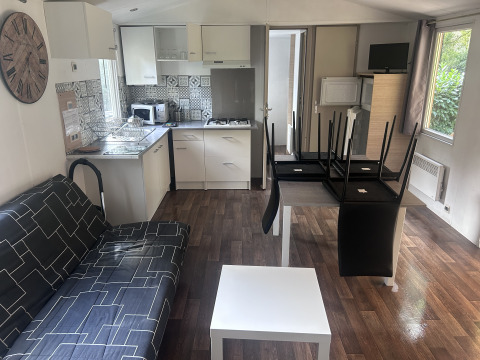 Interiør i sommerhus på Camping Seasonova du Chêne i Frankrig med moderne køkken og stueområde.