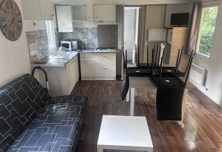 Interiør i sommerhus på Camping Seasonova du Chêne i Frankrig med moderne køkken og stueområde.