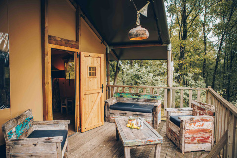 Gemütliche Holzterrasse mit rustikalen Möbeln an einem Safarizelt in Wilsumer Berge, Deutschland.