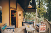 Gemütliche Holzterrasse mit rustikalen Möbeln an einem Safarizelt in Wilsumer Berge, Deutschland.