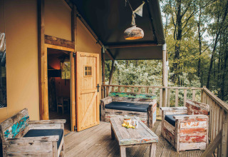 Gemütliche Holzterrasse mit rustikalen Möbeln an einem Safarizelt in Wilsumer Berge, Deutschland.