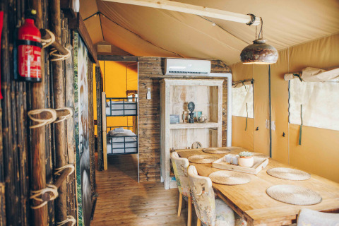Innenraum des Safari-Zeltes Safari tent at Wilsumer Berge in Deutschland mit Esstisch und Etagenbetten.