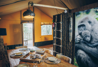 Innenaufnahme eines Safari-Zeltes bei Wilsumer Berge in Deutschland, Essbereich und Gorillabild.