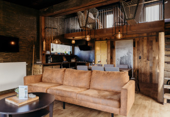 Zona giorno accogliente al lodge Juttershut di Duynpark Het Zwanenwater, Paesi Bassi, con dettagli in legno rustico.