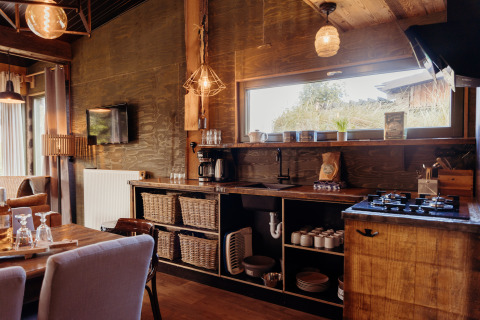 Gezellige keuken in de Juttershut lodge bij Duynpark Het Zwanenwater in Nederland, met houten accenten.