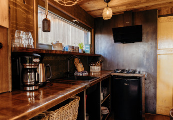 Accogliente cucina al Juttershut, Duynpark Het Zwanenwater, Paesi Bassi, con piano cottura a gas e ripiani in legno.