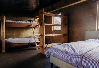 Dormitorio acogedor en Juttershut, Duynpark Het Zwanenwater, con literas de madera y cama individual.
