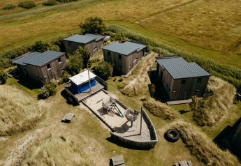 Vista aerea di cabine e parco giochi a forma di nave al lodge Juttershut, Duynpark Het Zwanenwater.