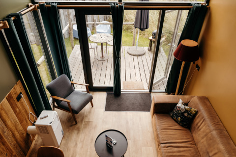 Vue du dessus du salon du Rescue cottage à Duynpark Het Zwanenwater avec terrasse et décoration moderne.