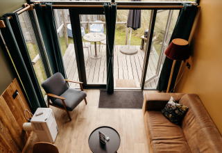 Overhead view of Rescue cottage living room at Duynpark Het Zwanenwater with terrace and cozy decor.