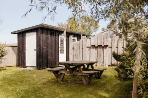 Tavolo da picnic e casetta in legno presso Rescue Cottage nel Duynpark Het Zwanenwater, Paesi Bassi.