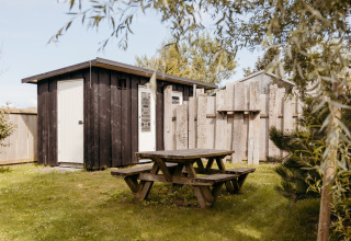 Udendørs picnicbord og træhytte set ved Rescue Cottage i Duynpark Het Zwanenwater, Holland.