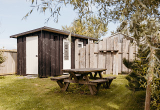 Mesa de picnic y cabaña de madera en el Rescue Cottage de Duynpark Het Zwanenwater, Países Bajos.