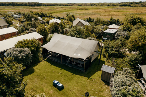 Vista aérea de la tienda safari Wood Lodge en Duynpark Het Zwanenwater, Países Bajos, rodeada de naturaleza.