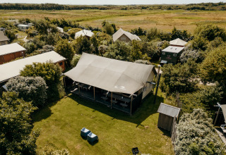 Vista aérea de la tienda safari Wood Lodge en Duynpark Het Zwanenwater, Países Bajos, rodeada de naturaleza.