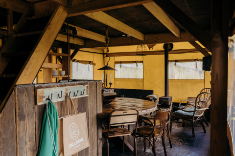 Interior de una tienda safari llamada Wood Lodge en Duynpark Het Zwanenwater, Países Bajos, con decoración rústica.