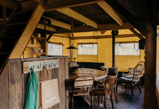 Interior de una tienda safari llamada Wood Lodge en Duynpark Het Zwanenwater, Países Bajos, con decoración rústica.