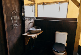 Bagno in tenda safari Wood Lodge, Duynpark Het Zwanenwater, Paesi Bassi, con toilette e lavabo in pietra.
