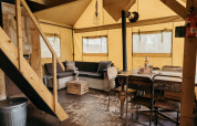 Interior view of Beach Lodge safari tent with rustic furniture and wood décor at Duynpark Het Zwanenwater.