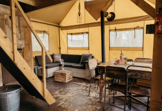 Vista interior de la tienda safari Beach Lodge con muebles rústicos en Duynpark Het Zwanenwater, Países Bajos.