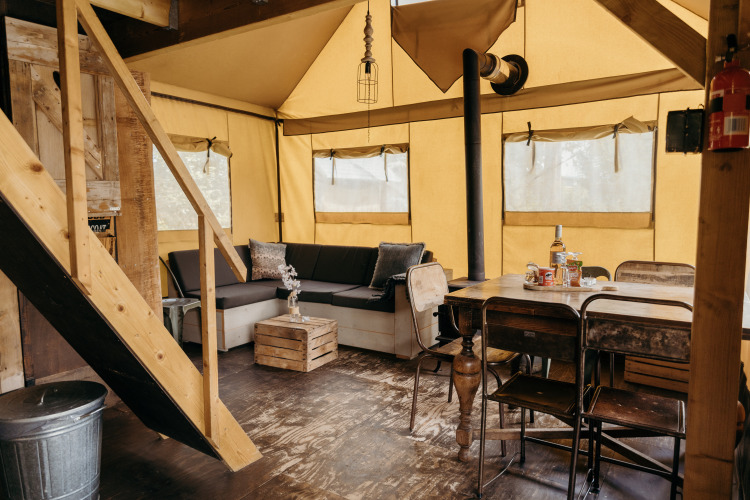 Interieur van Beach Lodge safaritent met rustieke meubels bij Duynpark Het Zwanenwater in Nederland.