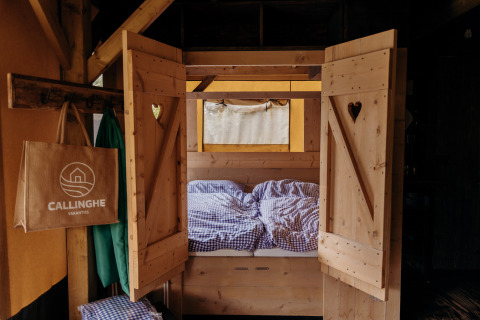 Cama acogedora en tienda safari Beach Lodge de Duynpark Het Zwanenwater en los Países Bajos.