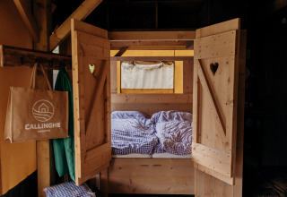 Cama acogedora en tienda safari Beach Lodge de Duynpark Het Zwanenwater en los Países Bajos.