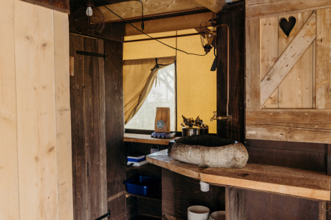Spazio cucina rustico in una tenda safari Beach Lodge presso Duynpark Het Zwanenwater, Paesi Bassi.
