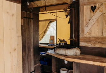 Spazio cucina rustico in una tenda safari Beach Lodge presso Duynpark Het Zwanenwater, Paesi Bassi.