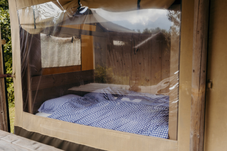 Interieur van een Beach Lodge-safaritent bij Duynpark Het Zwanenwater met geruit beddengoed, Nederland.