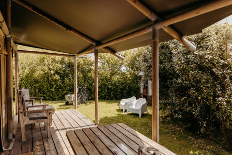 Gemütliche Terrasse mit Holzstühlen am Safari-Zelt Beach Lodge im Duynpark Het Zwanenwater, Niederlande.