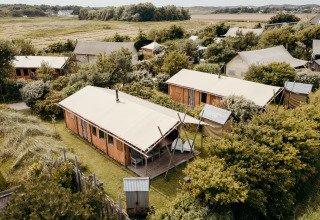 Luchtfoto van safaritenten met groene natuur bij Duynlodge, Duynpark Het Zwanenwater, Nederland.