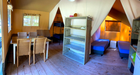 Intérieur d'une tente glamping familiale avec coin repas à Vakantiepark Bonte Vlucht, Utrecht, Pays-Bas.