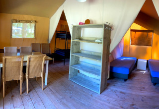 Interior of a comfortable family glamping tent with sleeping and dining area at Vakantiepark Bonte Vlucht, Utrecht.