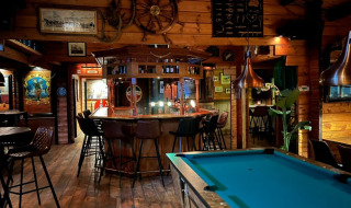 Rustik pub med billardbord og bar i træ, en af hovedattraktionerne i Parc Koudenburg, Friesland.
