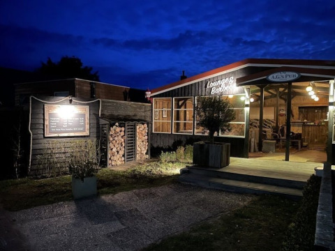 Abendliche Aufnahme einer gemütlichen Bar im Ferienpark Parc Koudenburg in Friesland, Niederlande.