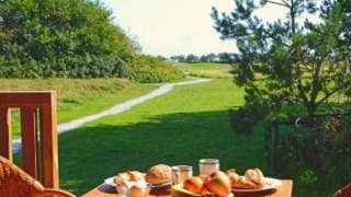 Mesa de desayuno al aire libre con comida frente a zonas verdes en Parc Koudenburg, Frisia, Países Bajos.