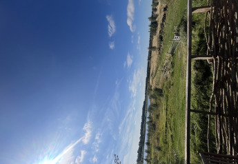 Vista da una tiny house al Holiday park Eigen Wijze nei Paesi Bassi, con prati verdi e cielo azzurro.