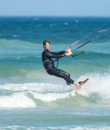 Hombre practicando kitesurf en el mar cerca de Hollum, Frisia, Países Bajos, vistiendo un traje de neopreno.