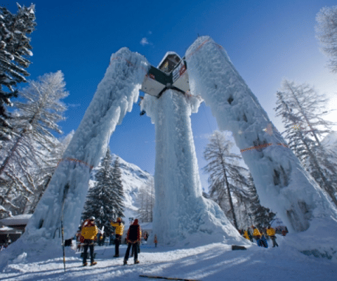 Des personnes admirent une immense structure de glace à Les Chalets Huttopia Champagny en Vanoise, en Auvergne-Rhône-Alpes.