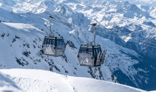 Deux cabines de télécabine à La Plagne entourées de sommets alpins enneigés près de Champagny-en-Vanoise, France.