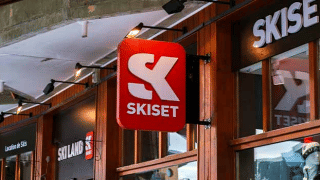 Entrée de la boutique Skiset à Les Chalets Huttopia Champagny en Vanoise, devanture bois et enseigne visible.