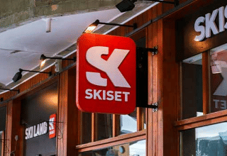 Entrance to a Skiset store at Les Chalets Huttopia Champagny en Vanoise, shown with wood facades and signage.
