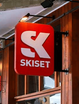 Entrée de la boutique Skiset à Les Chalets Huttopia Champagny en Vanoise, devanture bois et enseigne visible.